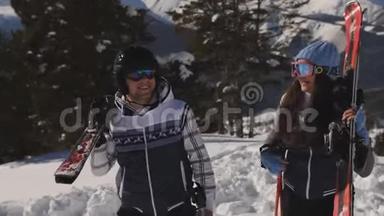 一<strong>双手拿</strong>着滑雪板的滑雪者爬到山顶..